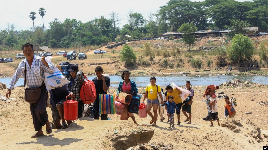 FILE - People cross the Moei river as they flee Myawaddy township in Myanmar to Thailand's Mae Sot town in Thailand's Tak province, April 20, 2024. 