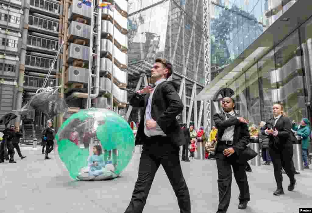 Activists from Mothers Rise Up, a campaign for climate action, dance outside Lloyd's of London.