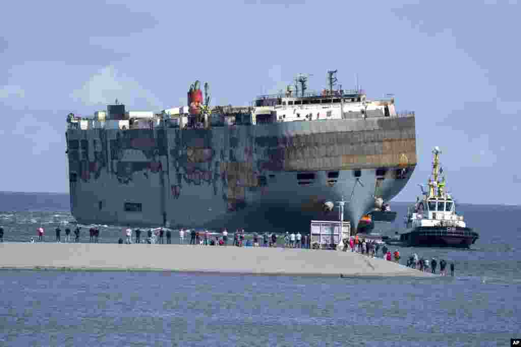 Stricken cargo ship Fremantle Highway that caught fire while transporting thousands of cars, including nearly 500 electric vehicles, from Germany to Singapore, is towed into the port of Eemshaven, the Netherlands. The ship that burned for almost a week close to busy North Sea shipping lanes and a world renowned migratory bird habitat will be salvaged at the northern Dutch port. 