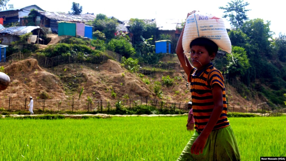 A Rohingya boy carries food rations for his family from a World Food Program-run shop in a refugee camp, Cox’s Bazar, Bangladesh, June 12, 2022.