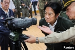 台湾总统赖清德在视察桃园军事基地时查看一架激光测距仪。（2024年5月23日）