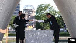 在广岛和平纪念公园举行的仪式上，广岛市长松井一实和死者家属代表将原子弹爆炸遇难者名单安放在纪念碑上。(2023年8月6日)