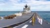 FILE - The HMAS Canberra's crew muster on the upper decks as the ship sails into Pearl Harbor, Hawaii, on June 28, 2022. 