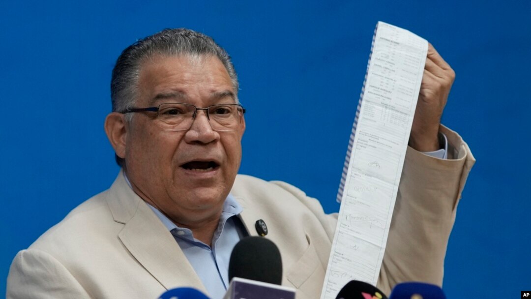 Former presidential candidate Enrique Marquez of the Centrados Party holds an election results tally sheet during a press conference about the disputed presidential election in Caracas, Venezuela, Aug. 14, 2024.