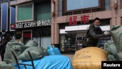 资料照片：中国北京一名男子在一个出售俄罗斯商品和服务的交易中心前搬运出口货物。（2022年4月1日）