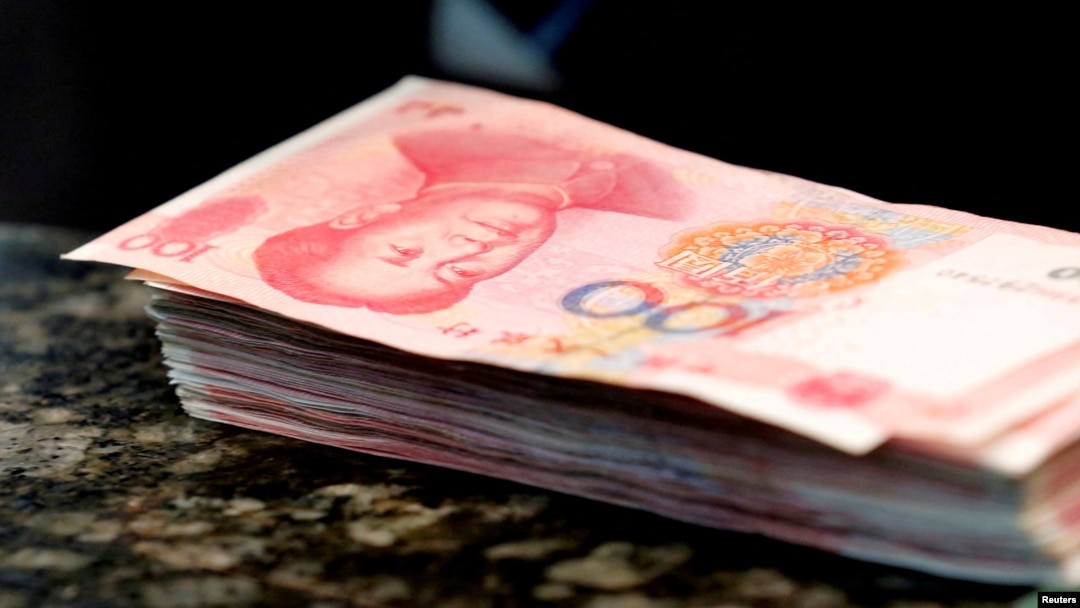 FILE - Chinese 100 yuan banknotes sit on a bank counter in Beijing, March 30, 2016. The Chinese currency has plummeted since former U.S. President Donald Trump was elected to another term on Nov. 5.