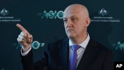 FILE - Australian Security Intelligence Organization director-general Mike Burgess points in Canberra, Australia, Nov. 28, 2022. Burgess said China’s economic espionage went far beyond “traditional” spying because it had been approved by the government over many years.