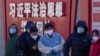 北京市民在宣传习近平思想的标语墙前排队等候进行核酸检测。（2022年12月5日）