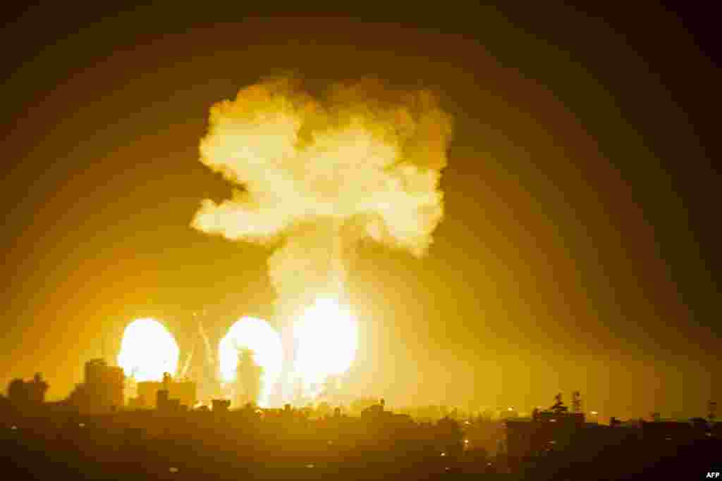 A ball of fire and a plume of smoke rise above buildings in south of Gaza Strip as Israeli warplanes target the Palestinian enclave.