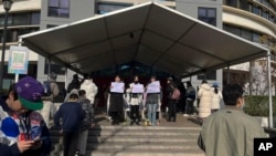 北京清华大学的学生手举白纸抗议严厉的防疫政策，悼念日前在新疆乌鲁木齐市死于火灾的至少10名遇难者。 （2022年11月27日）