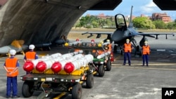 台湾军队士兵站在F16V战机前，准备进行装载美制AGM-84鱼叉反舰导弹、AIM-120和AIM-9空空导弹的训练。（2022年9月16日）