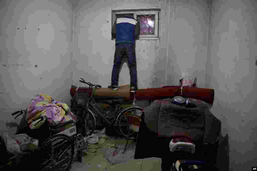 A man looks outside the window of an apartment where migrant workers stayed in the outskirts of Beijing, China, Nov. 27, 2017. Authorities have been evicting domestic migrant workers from the capital in droves, triggering a public outcry over the harsh treatment of people the city depends on to build their skyscrapers, care for their children and take on other lowly-paid work.