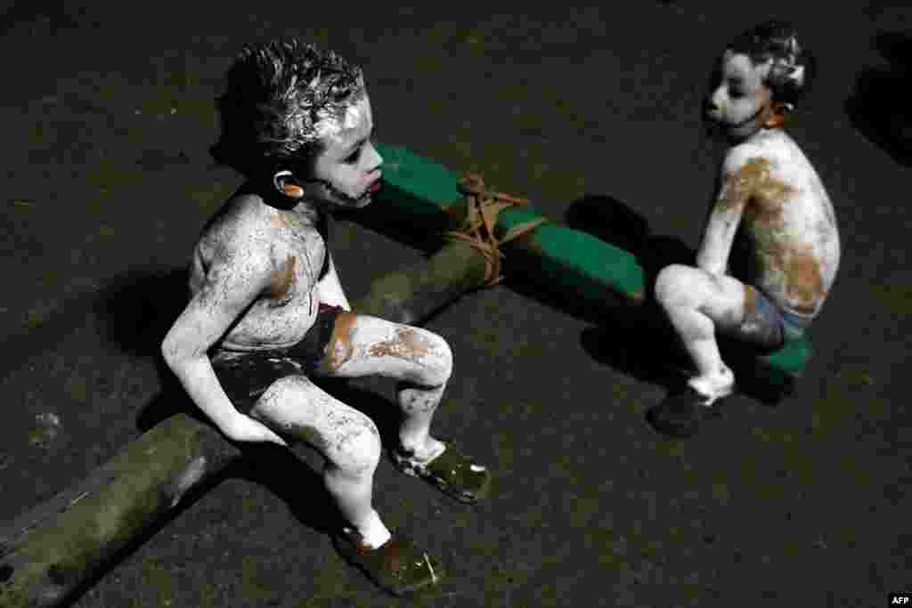 Two boys take part in a parade called "La Calabiuza" on the eve of the Day of the Dead in Tonacatepeque, 20 kilometres north of San Salvador, El Salvador.