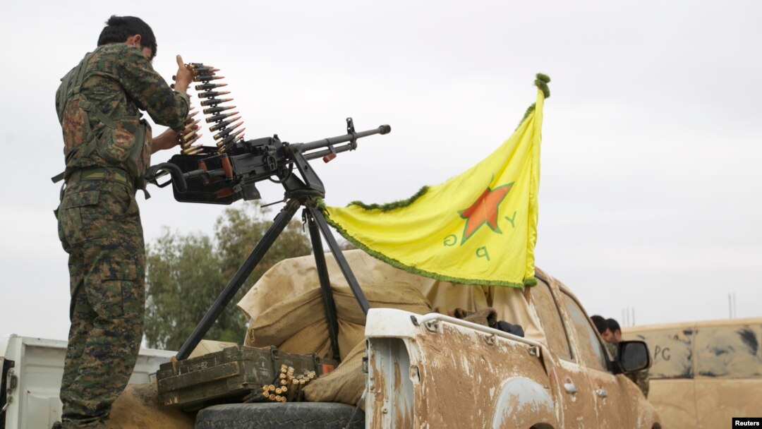 FILE - A Kurdish fighter is seen atop a pickup truck near the city of Ras al-Ain, Syria, Nov. 5, 2013.