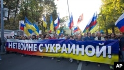 Российские и украинские флаги в руках у участников протестной акции против войны в Украине (архивное фото)