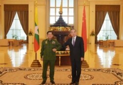In this Jan. 12, 2021, file photo provided by Myanmar Military Information Team, Myanmar's Army Commander Senior Gen. Min Aung Hlaing, left, and Chinese Foreign Minister Wang Yi pose for a photo during their meeting in Naypyitaw, Myanmar.