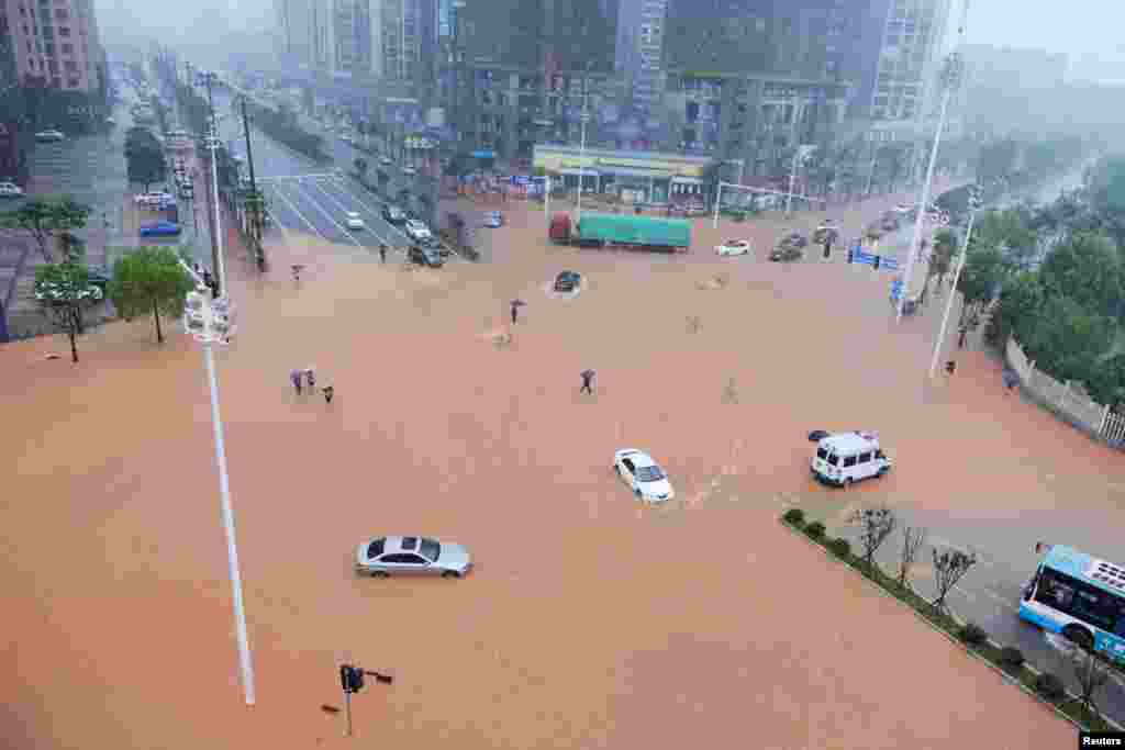 湖南长沙,暴雨中行人和车辆过马路(2017年7月1日)。湖南省防汛抗旱指挥部表示, 这轮强降雨总量之多、范围之广、强度之大、历时之长,洪峰水位之高、超过历史河段之多均为历年罕见。中国民政部向浙江、江西、湖南、贵州4省安排了7亿元中央财政自然灾害生活补助资金。