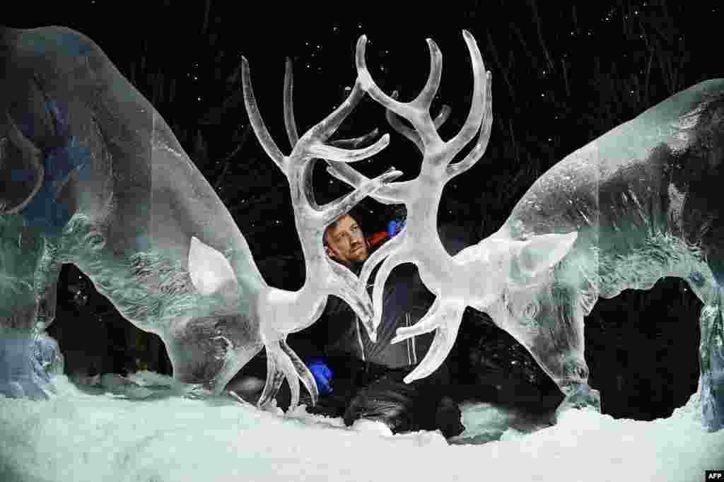 Ice sculptor Darren Jackson puts the finishing touches to an ice sculpture of two stags, which makes up part of a forthcoming exhibition, "The Ice Adventure: A Journey Through Frozen Scotland," in Edinburgh, Scotland, Nov. 14, 2017.