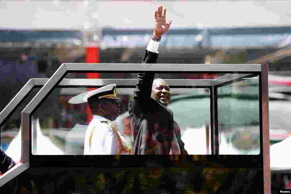 Kenya's President Uhuru Kenyatta waves upon his arrival to his inauguration ceremony where he will be sworn in as president at Kasarani Stadium in Nairobi.