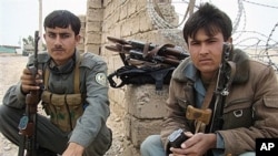 Cảnh sát Afghanistan canh gác trước cổng chính của cơ sở dân sự-quân sự chung ở Lashkar Gah, tỉnh Helmand, nơi 2 binh sĩ Anh bị một binh sĩ Afghanistan bắn chết, ngày 26/3/2012