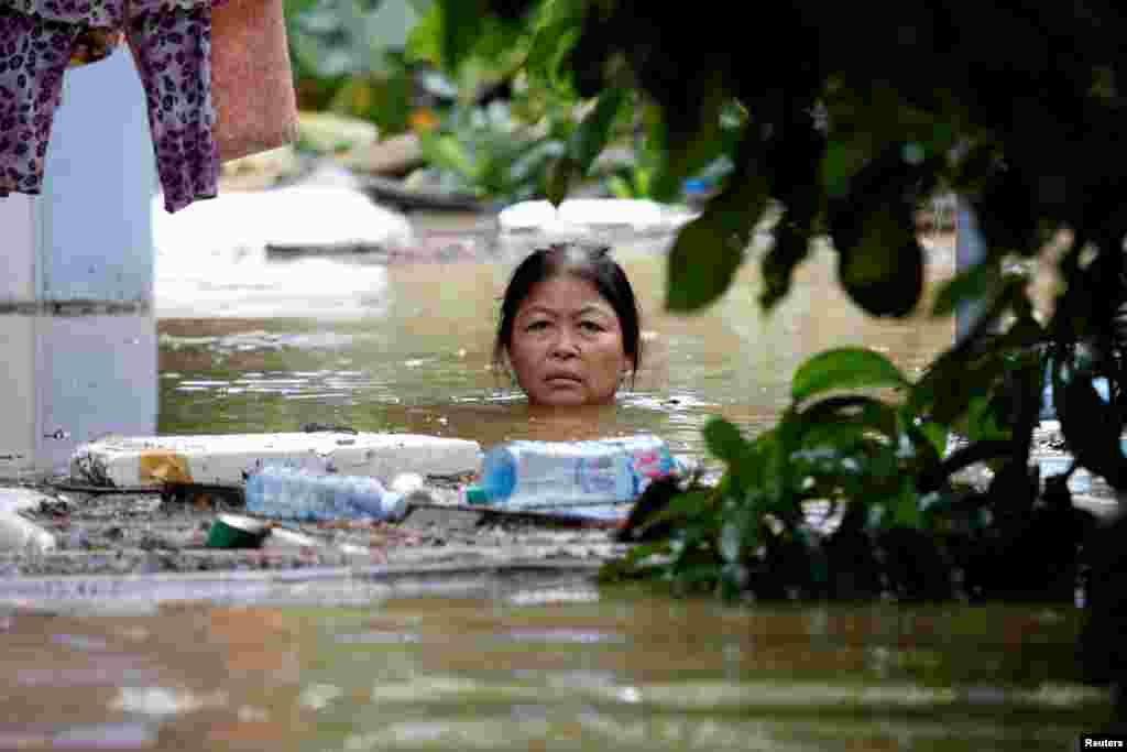 A woman wades through a submerged street at the UNESCO heritage ancient town of Hoi An after typhoon Damrey hits Vietnam.