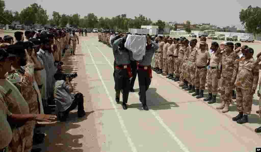 Pakistani paramilitary troops carry the coffin of their colleague who died during Sunday's attack on Jinnah International Airport, during his funeral in Karachi, Pakistan, June 9, 2014.