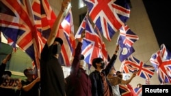 资料照：香港抗议者手举英国国旗在英国驻港总领事馆前集会。（2019年10月23日）