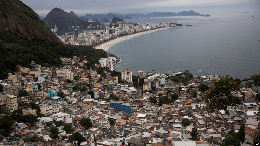 FILE - Brazil Favela Tourism, men overlook the city from the Vidigal slum, in Rio de Janeiro, Brazil, Oct. 29, 2017.