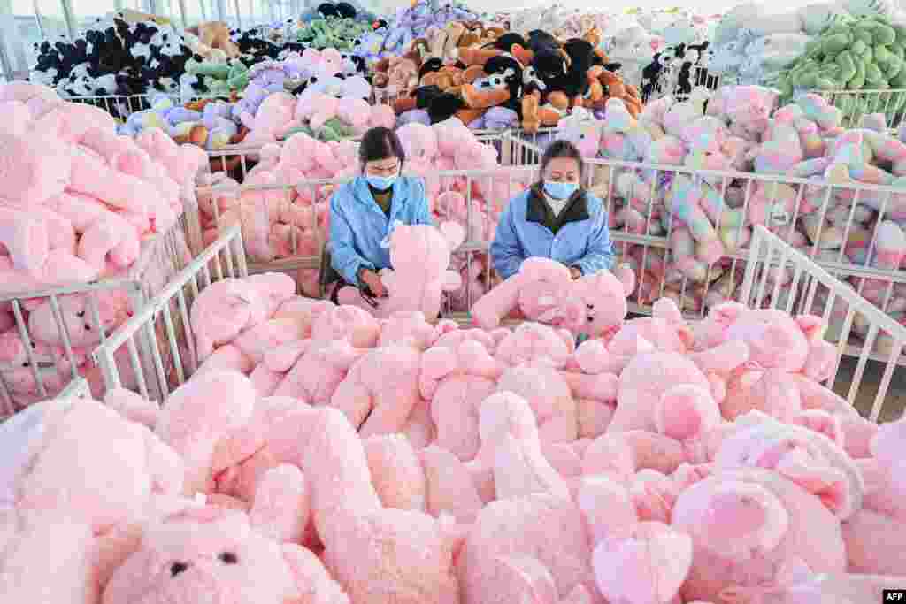 Employees work on a production line of stuffed teddy bears for export at a toy factory in Lianyungang, in eastern China's Jiangsu province. (Photo by AFP) / China OUT