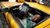 FILE - Taxi driver Roland Sainristil displays the driver's ZabKab app on his smartphone, in New York, Aug. 8, 2012. The app lets a passenger send out a hailing signal to all cabs within a four- or five-block area. Now, however, cabs themselves are in for makeovers that will make for a more pleasant passenger experience.
