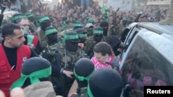 Militantët e Hamasit dorëzojnë pengun Doron Steinbrecher tek pjesëtarët e Kryqit të Kuq si pjesë e marrëveshjes së armëpushimit dhe këmbimit të pengjeve me të burgosurit mes Hamasit dhe Izraelit, në Gazë, më 19 janar, 2025/Reuters