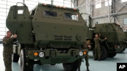资料照片：波兰士兵在华沙的一个空军基地查看搭载有美国制造的“海马斯”(HIMARS)火箭发射器的军车。(2023年5月15日)