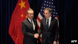 美国国务卿布林肯（图右）同中共中央外事办公室主任王毅抽空在东盟外长会议期间见面握手并讨论双边关系。