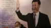 中国辽宁省沈阳市的一家书店里一名戴着口罩的读者坐在中国国家领导人习近平的大幅画像前。（2020年4月23日）