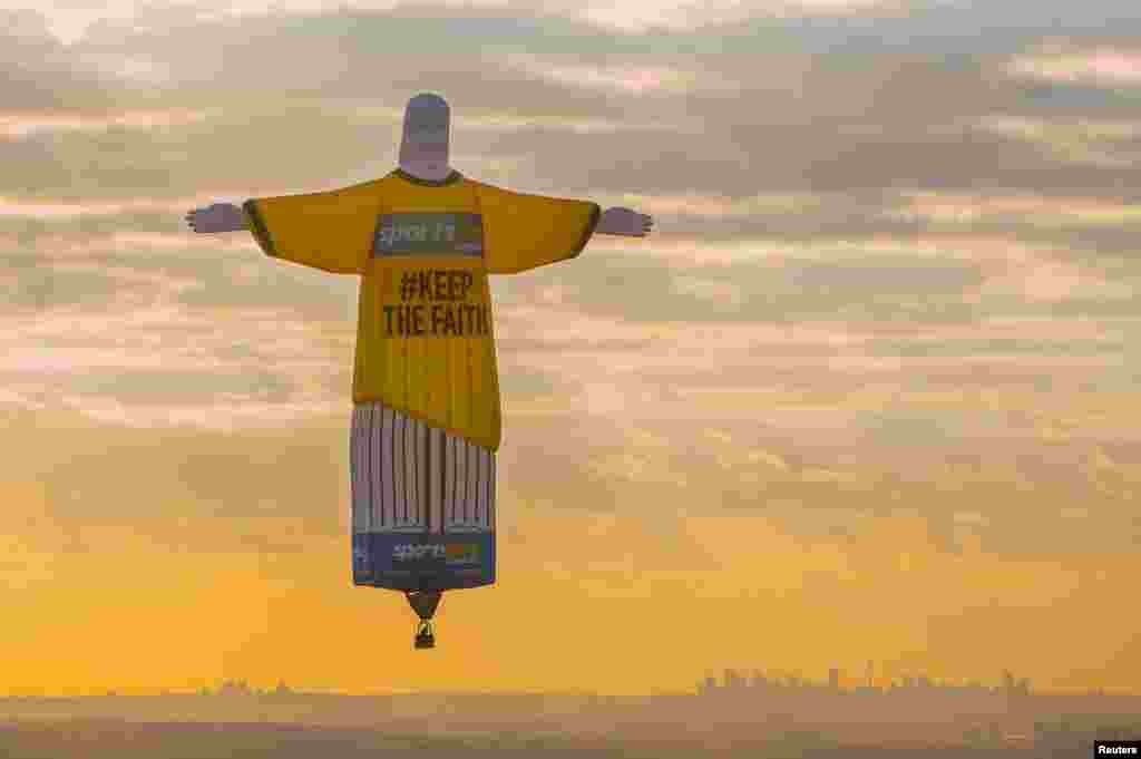 A balloon shaped in the famous 'Christ the Redeemer' statue floats at sunrise above the Australian city of Sydney, Australia.