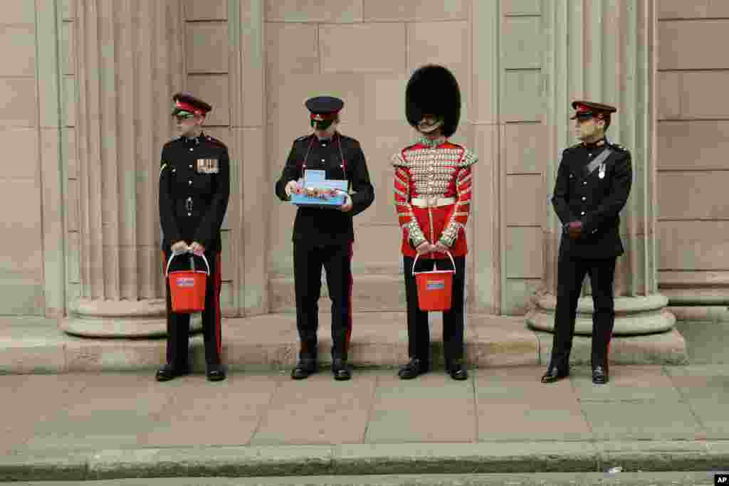 Members of the British military's Honorable Artillery Company collect donations for the annual poppy appeal ahead of Armistice Day outside the Bank of England in the City of London.