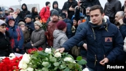 2015年2月28日，反对派活动人士伊利亚·亚辛（Ilya Yashin）在涅姆佐夫遇刺地点献花悼念。