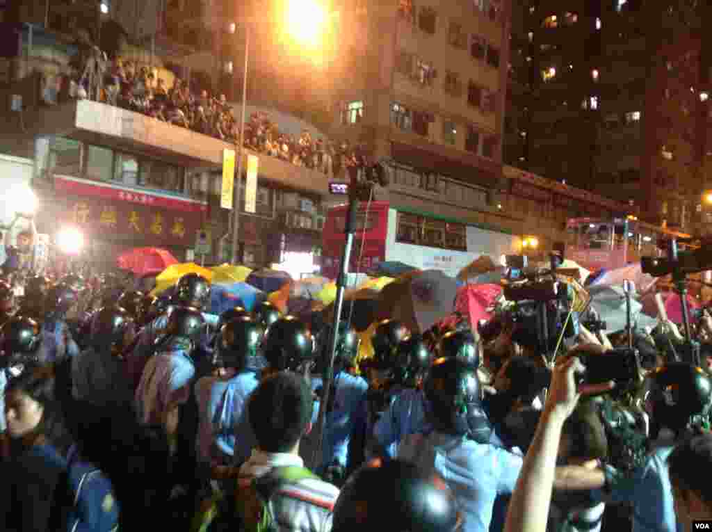 示威者在9点过后占据了中联办外一段德辅道,并在中联办后门外与警方防线展开推撞,警方用辣椒喷雾还击将示威者防线推后。示威者不断呼喊反对释法。