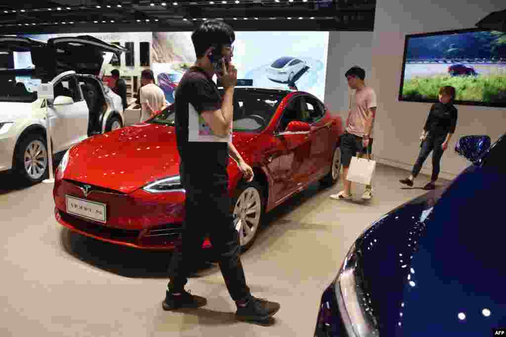 2018年5月23日,人们在北京的特斯拉展厅里观看汽车。5月15日美国多家媒体报道了特斯拉公司在上海注册成立了一家新的独资公司的消息。消息来源是中国政府的“全国企业信用信息公示制度”的网站。但根据中国官方发布的消息,这家独资公司的业务范围只涉及汽车和电池产品的技术开发和服务,并不包括电动车的生产制造。彭博新闻社报道:这是特斯拉“向在中国生产电动汽车迈进了一步,并在美国境外建立第一家千兆电池制造厂。”