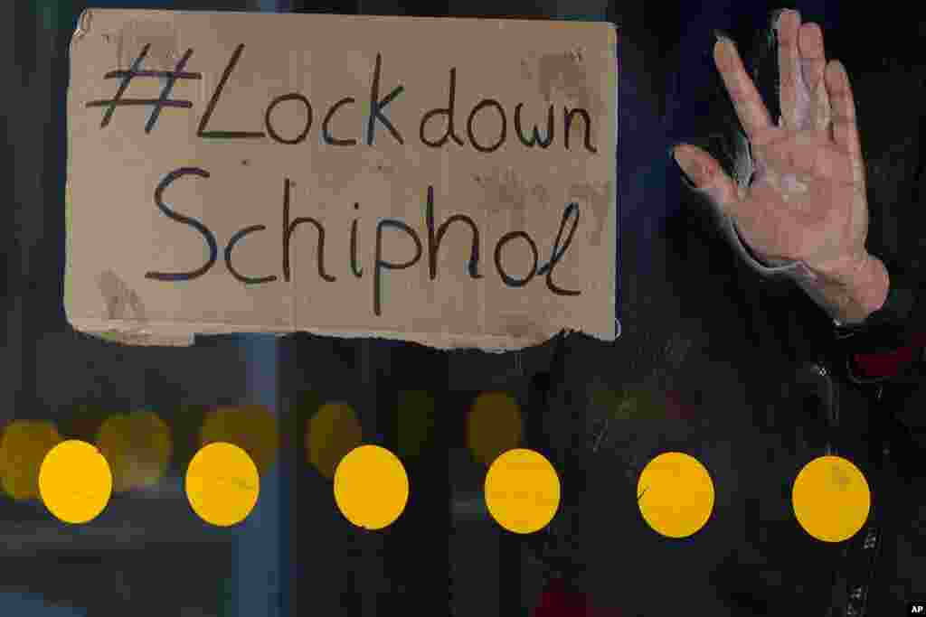 The hand of an activist is glued to a revolving door of one of the entrances to Schiphol Airport, near Amsterdam, Netherlands.