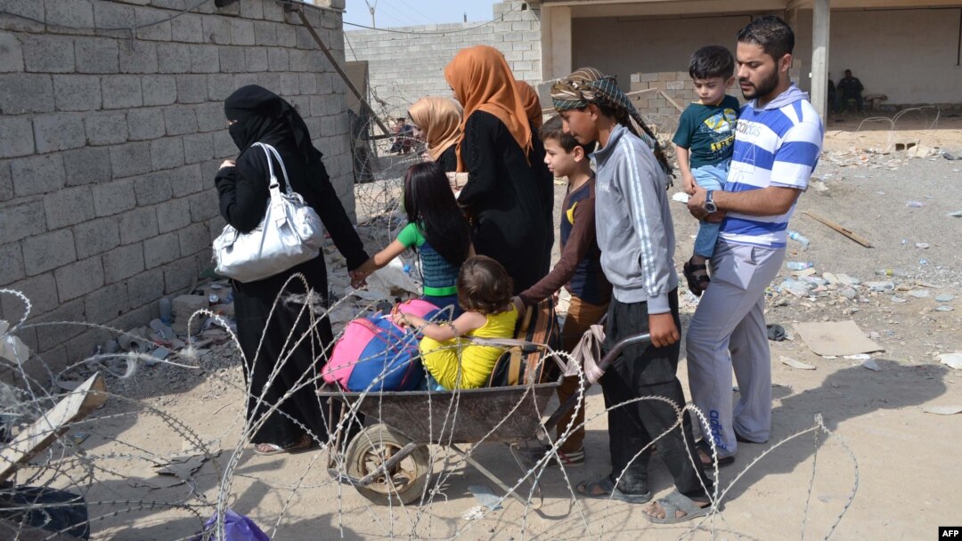 Iraqi families fleeing Islamic State (IS) group advance in their towns arrive to take refuge in a Kurdish-controlled area in Mullah Abdullah, some 25 kms west of Kirkuk, Oct. 15, 2014.