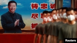 2020年5月22日，中国武装警察官兵在北京故宫外列队，背景是中国领导人习近平的宣传画板。