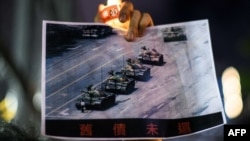 在香港维多利亚公园参加纪念六四事件31周年的一名男子手持天安门广场“坦克人”的照片。（2020年6月4日）
