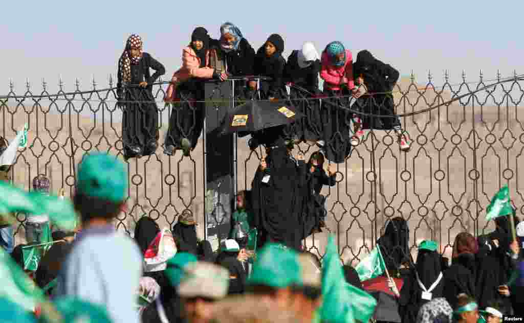 Houthi supporters hang off an iron fence during a rally marking the birth anniversary of Islam's Prophet Mohammad, in Sana'a, Yemen.
