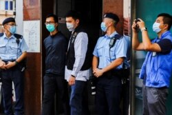 香港警察逮捕了支联会成员之一梁锦伟（左二）。（2021年9月9日）