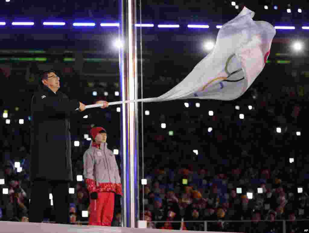 平昌冬奥会闭幕式上，北京市长陈吉宁挥舞奥运旗帜。北京将主办2022年冬奥会（2018年2月25日）