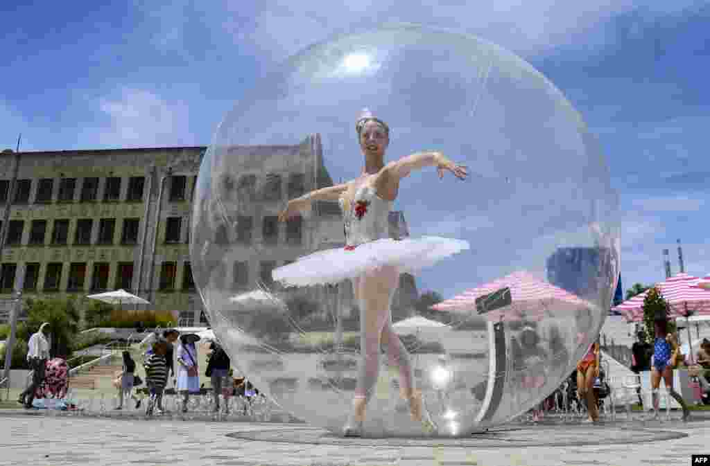 A ballet dancer poses in a giant plastic bubble as she entertains Christmas shoppers in Melbourne, Australia.