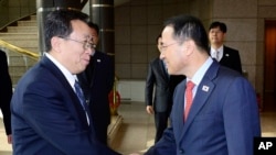 韩国代表团团长金奎显（右）在板门店与朝鲜代表团团长元东渊握手。（2012年2月12日）
