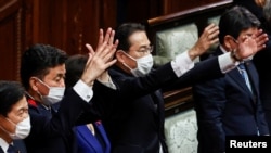 日本首相岸田文雄（中）2021年10月14日在解散众议院后挥手打气（路透社）