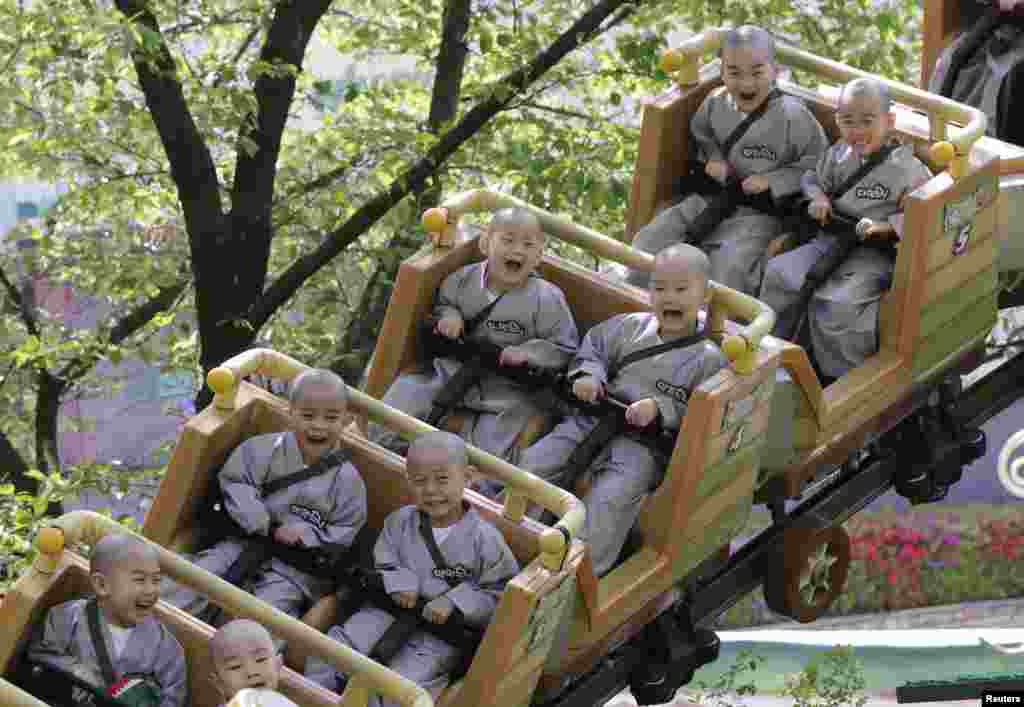 Child monks ride in a roller coaster during their visit to the Everland amusement park in Yongin, South Korea.